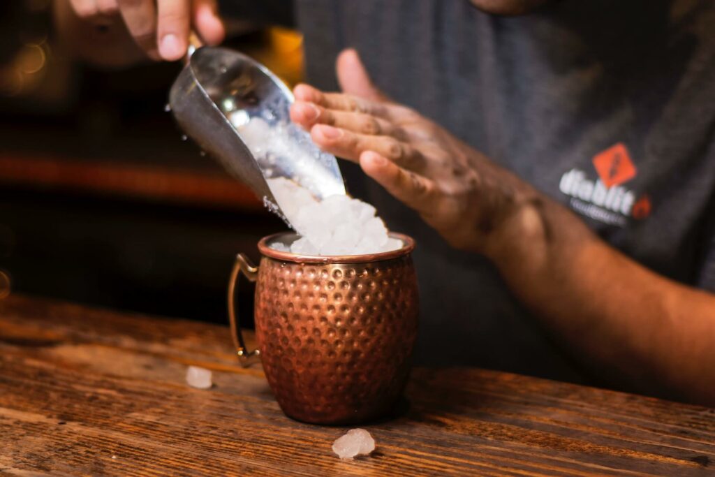 bartender making moscow mule in a copper mug