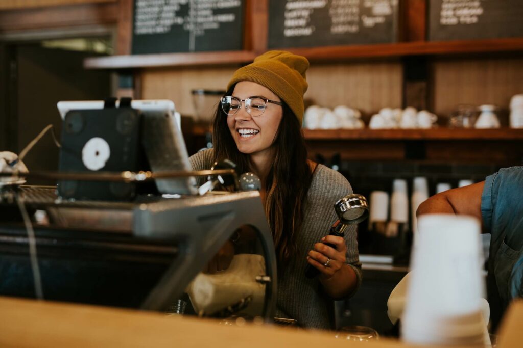 female barista smiling while using the till